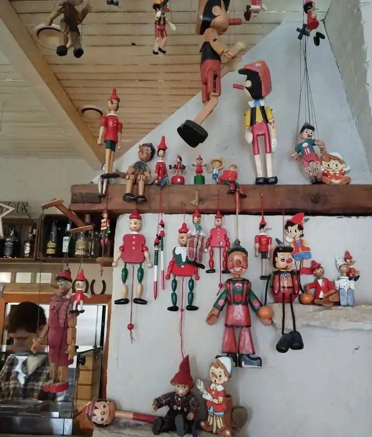 Ściana pełna drewnianych marionetek Pinokia nad barem