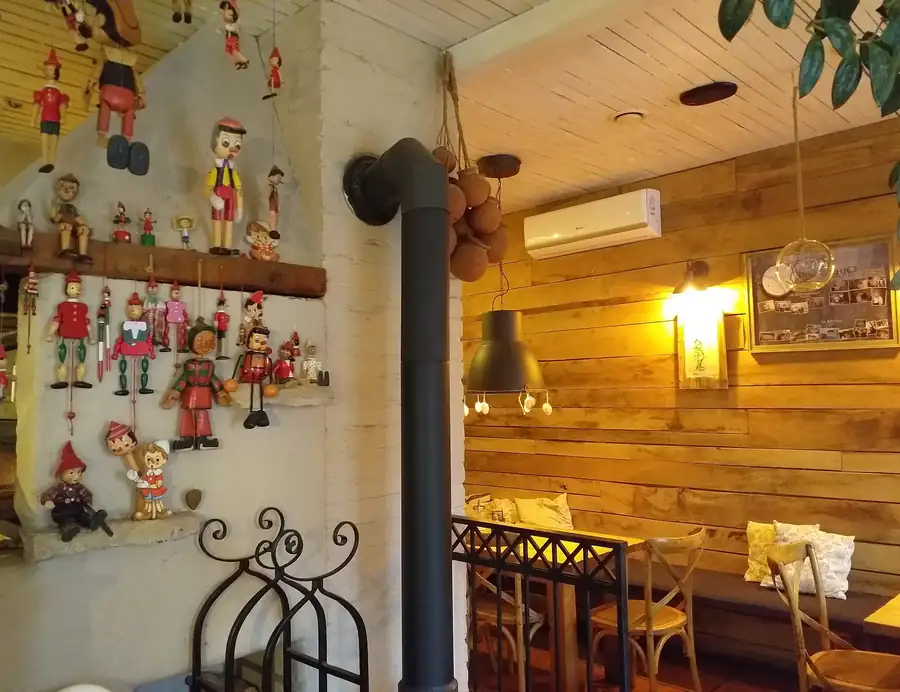 Sala z marionetkami na ścianie i drewnianą boazerią